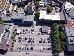 Ahrensburg: Luftaufnahme Richtung Westen: Rathausplatz mit parkenden PKW und angrenzenden Gebäuden