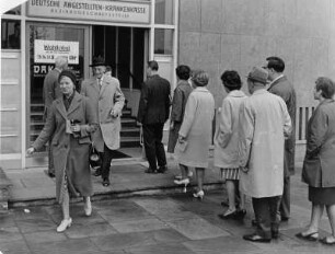 Sozialwahlen bei der Deutschen Angestellten Krankenkasse (DAK) 1962. Mitglieder stehen vor dem Wahllokal der Bezirksgeschäftsstelle an. Andere kommen nach vollzogener Wahl wieder heraus.