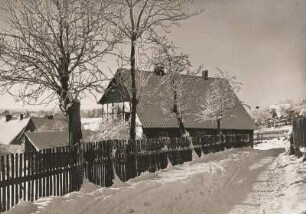 Winter im Osterzgebirge. Tief verschneites Bauernhaus in Kipsdorf