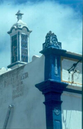 Blau-weißer Schornstein, passend zur dekorativen Fassade des Daches