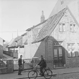 Hagenstraße: Gebäude Nr. 6, davor Passant und Fahrradfahrer