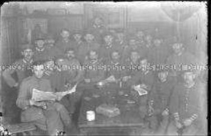 Gruppenbild mit 24 Soldaten um einen Tisch gruppiert