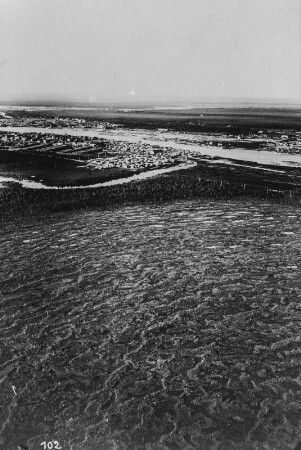 Holzlager und Tundralandschaft : Eine Tundralandschaft im Vordergrund, dahinter ein Holzlager bei Archangelsk und die nördliche Dwina. Arktisfahrt des Luftschiffs "Graf Zeppelin" im Auftrag der Internationalen Gesellschaft zur Erforschung der Arktis mit Luftfahrzeugen (AERO ARCTIC) vom 23.-31 Juni 1931