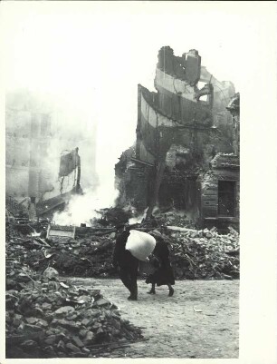 Bewohner einer zerbombten Stadt zwischen Ruinen und Trümmern (vermutlich Hamburg)
