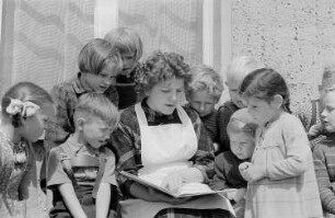 Eine Kindergärtnerin liest Kindern vor