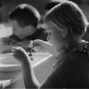 Ganztagsschule (Spielen-Lernen-spielend lernen). Schulspeisung. Grundschülerin beim Mittagessen (wahrscheinlich in der Haydnschule in Dresden-Striesen)