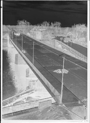 Staustufe Schweinfurt. Straßenbrücke. Aufbringung der 1. Lage Gussasphalt auf der Fahrbahn. Rechts die alte Maxbrücke. Schweinfurter Pegel = 97 cm.