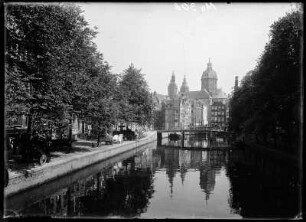 Amsterdam, Niederlande. Blick entlang einer Gracht zur Basilika St. Nikolaus