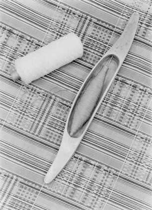 Garnrolle und Weberschiffchen : Garnrolle und Weberschiffchen auf einer Webarbeit der Lausitz mit geometrischem Muster (Motiv als Vignette "Handgewebt")