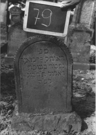 Grabstein 79 (Index: 100114068) Material: Sandstein Zustand: leicht verwittert Maße HxBxT: 60x33x15 cm Beschreibung: Stele, Sockel, Rundbogenabschluß Symbolik: Diamantfries Besonderheit: Kindergrab: Grabstein 79