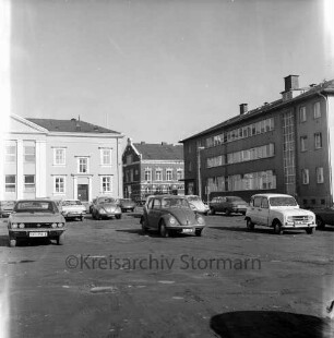 Hagenstraße: vorne parkende Pkws, im Hintergrund das Rathaus, rechts das Stadthaus: Blick von Nordosten
