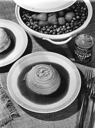 Krafts Rezeptaufnahmen. Nudelschnecke mit Soße. Daneben eine Dose Parmesan und eine Terrine mit Gemüse