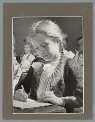 Portrait eines schreibenden Mädchens im Klassenzimmer