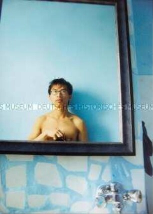 Junger, asiatischer Mann mit nacktem Oberkörper fotografiert sich vor einem Badezimmerspiegel (Sonderthema: Ein Bild von mir - Selbstporträts und Selbstdarstellungen)