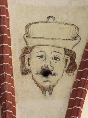 Kopf eines bärtigen Mannes mit Mütze und Kondenswasseröffnung als Mund