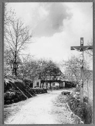 Zur Osterzeit in der Lausitz. Blick auf ein Gehöft mit Kruzifix und Umgebindehaus