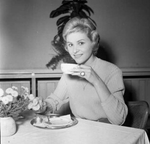 Frau am Kaffeetisch sitzend