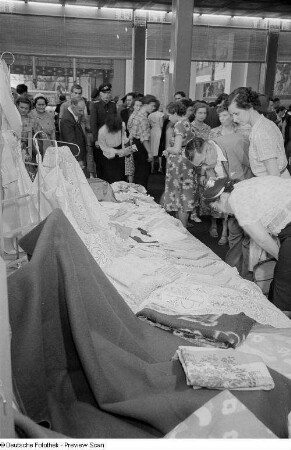 Besucher der Leipziger Herbstmesse 1954 betrachten Textilien der indischen Sektion