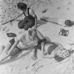 Mehrere Personen liegen am Strand