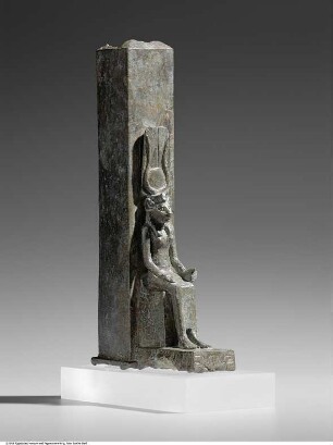Tiersarg in Form eines Obelisken, davor eine Figur der thronenden Göttin Wadjet