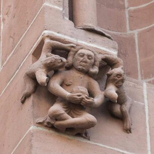 Nördliches Querhausportal — Hockender Mann mit drohenden Wesen
