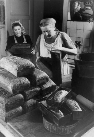 Bauernhof in Scharnebeck bei Lüneburg. Bäuerinnen backen Brot. Die fertigen Brotlaibe werden aus den Formen genommen. Aufgenommen 1949