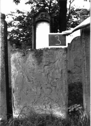 Grabstein 3 (Index: 100103719) Material: Sandstein Zustand: abgeblättert, oberer Teil der Stele abgebrochen, völliger Textverlust Maße HxBxT: 90x69x6 cm Beschreibung: Fragment: Unterteil einer Stele: Grabstein 3