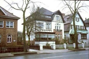 Kurparkallee 2: Bildmitte: Stadtvilla, Straßenfront: Mansarddach mit Fensterband, Obergeschoss und Zwerchgiebel mit Fachwerk: Auslucht, darauf Altan, links Veranda mit Verglasung