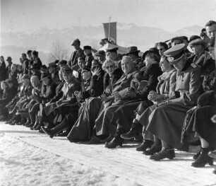 Dr. Robert Ley, Reichsleiter der NSDAP und Leiter der Deutschen Arbeitsfront mit Anhang und Frauen bei einer winterlichen Sportvorführung.