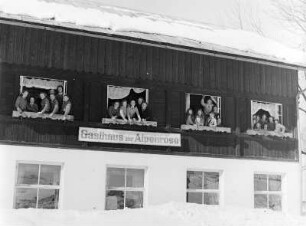 Mitglieder des Bundes Deutscher Mädel (BdM) an den Obergeschoßfenstern im Gasthaus zur Alpenrose