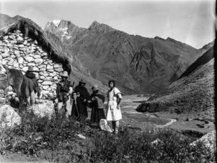 In Cooca : Fünf Bewohner aus Cooca vor einem Bruchsteinhaus, im Hintergrund die Cordillera Real.