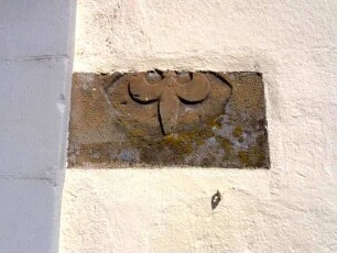 Langhaus (im Kern romanisch 11 Jh)-Traufseite Süd - Werkstein mit Ornamentik-Liliendarstellung (Hochreliefausführung) im Mauersteinverband