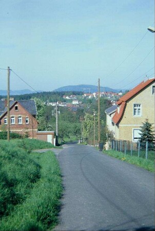 vereinzelt stehende Häuser am Ortsrand; hinten Ortsteil Weidhausen