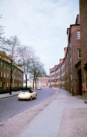 Mewesstraße: rechts und links Wohnblocks: links davor Bäume: links und hinten Mitte Pkws: hinten vor Wohngebäude Abzweigung der Ratzeburger Straße