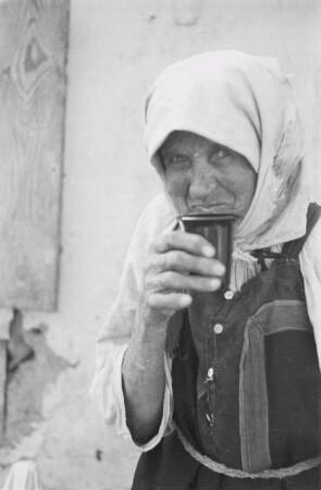 Zweiter Weltkrieg. Zur Einquartierung. Sowjetunion. Trinkende alte Bäuerin