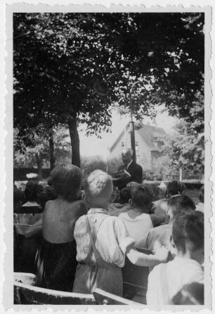 Der Autor und Fabeldichter Rudolf Kirsten liest vor Kindern in einem Park