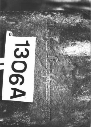 Grabstein 1306 (Index: 99900172) Material: Sandstein Zustand: stark verwittert Maße HxBxT: 140x56x28 cm Beschreibung: augesockelte Stele mit abgeflachtem Dreiecksabschluss, Stele steht nicht mehr standfest auf dem Sockel: Grabstein 1306A