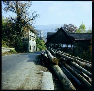 Neusatz: Straße mit Baumstämmen eines Sägewerks und Kirche