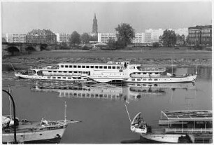 Personen-Seitenradmotorschiff "Karl Marx" auf der Elbe oberhalb Georgij-Dimitroff-Brücke (Augustusbrücke) auf Fahrt stromauf. Im Vordergrund Bug von MS "Ernst Thälmann" mit Bundstaken und Heck eines Dampfers mit Ankerdavit
