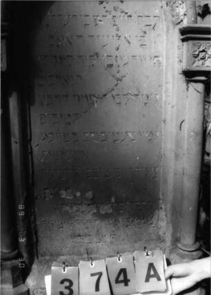 Grabstein 374 (Index: 99791775) Material: Sandstein Zustand: verwittert und abgeblättert mit Textverlust Maße HxBxT: 148x68x27 cm Beschreibung: ädikulaartige Stele mit Säulen, Sockel, eingezogener giebelartiger Abschluß, rechteckig erhöht, Schriftfeld eingetieft mit Rundbogenabschluß Symbolik: Blüten: Grabstein 374A