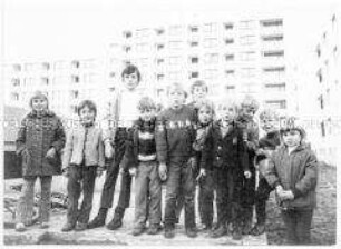 Eine Gruppe von Kindern vor mehrgeschossigen Wohnhäusern