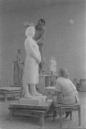 Beim Modellieren einer stehenden Frau mit verschränkten Händen. Gips (1960/1962) (Studentenarbeit der Bildhauerklasse von Walter Arnold)