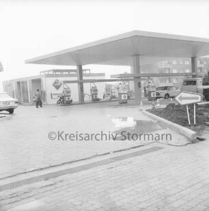 Aral Tankstelle: Hamburger Straße: in der Mitte Zapfsäulen mit Pkws: dahinter links Gebäude für Wartungsdienst und Mann: hinten rechts Wohnblock