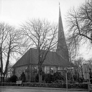 Friedenskirche, davor Kastanienbäume auf dem Kirchengelände, vorne die Hauptstraße