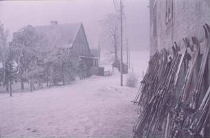 Erzgebirge. Verschneite Dorflandschaft mit Skiern an einem Haus