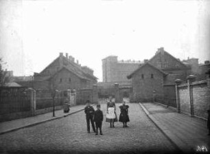 Eingang zum Zuchthaus. Bildmitte - Vier Kinder auf der Straße vor Eingangstor zum Zuchthaus