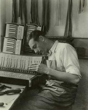Akkordeonbau in Zwota-Zechenbach : Akkordeonbau in Zwota-Zechenbach, Akkordeonfabrik „Hutschelli“ Paul Hutschenreuter und Müller. Akkordeonbauer bei der Montage des Griffes (Diskantklaviatur)
