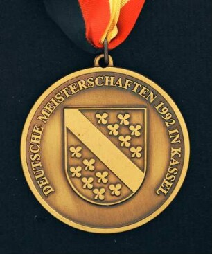 Bronzemedaille Deutsche Meisterschaften in Kurzschrift und Maschinenschreiben in Kassel 1992 am schwarz-rot-goldenen Band : Sammlung Deutscher Stenografenbund. Bronzemedaille Deutsche Meisterschaften in Kurzschrift und Maschinenschreiben in Kassel 1992 am schwarz-rot-goldenen Band. Messing, patiniert; Durchmesser 50 mm, Gewicht 39 g (1992; Deschler & Sohn, München). Dresden: SLUB R c 0562