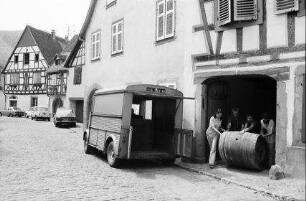 Kaysersberg: leere Weinfässer werden aus Haus gerollt
