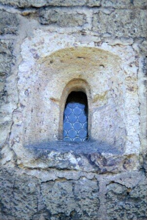 romanisches Rundbogenfenster im Kirchenschiff, aus einem einzigen Stein gehauen